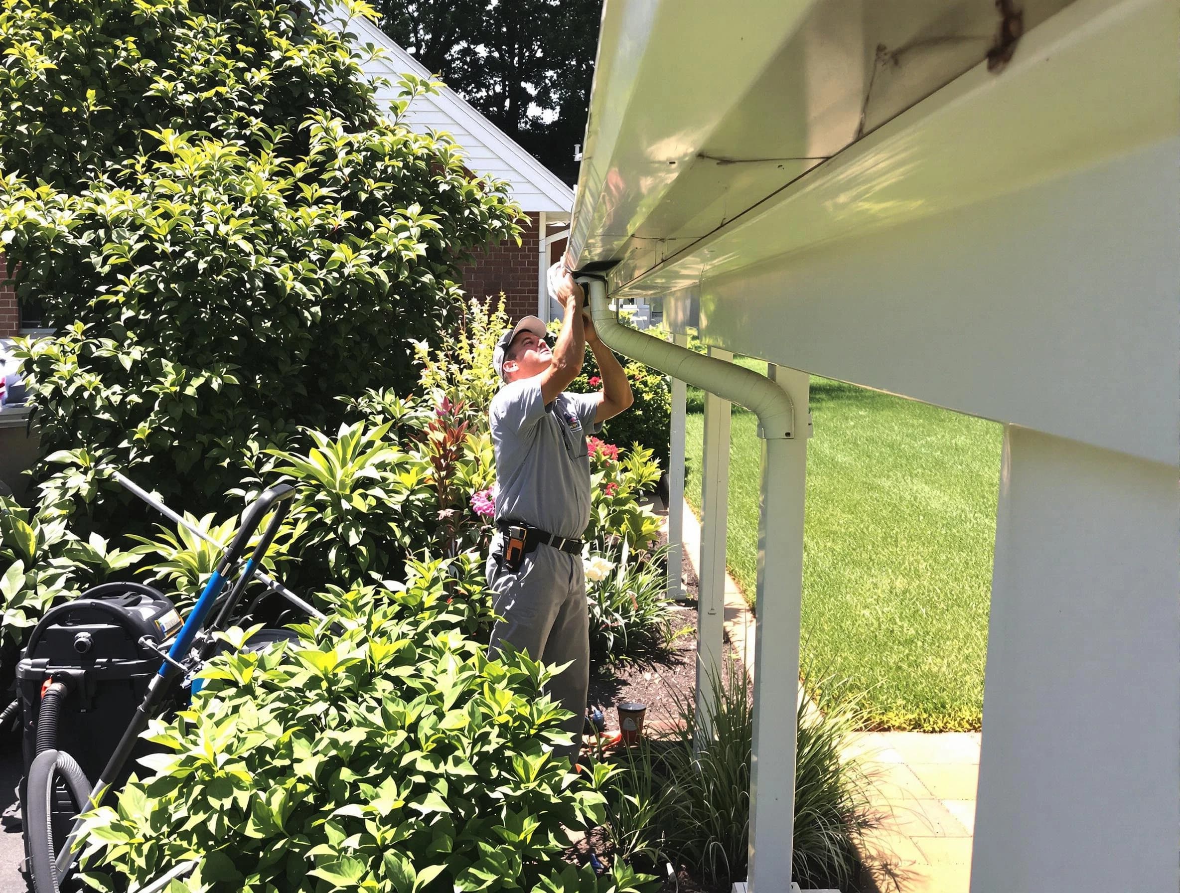 Technician flushing a blockage from a downspout in Avon Lake, OH